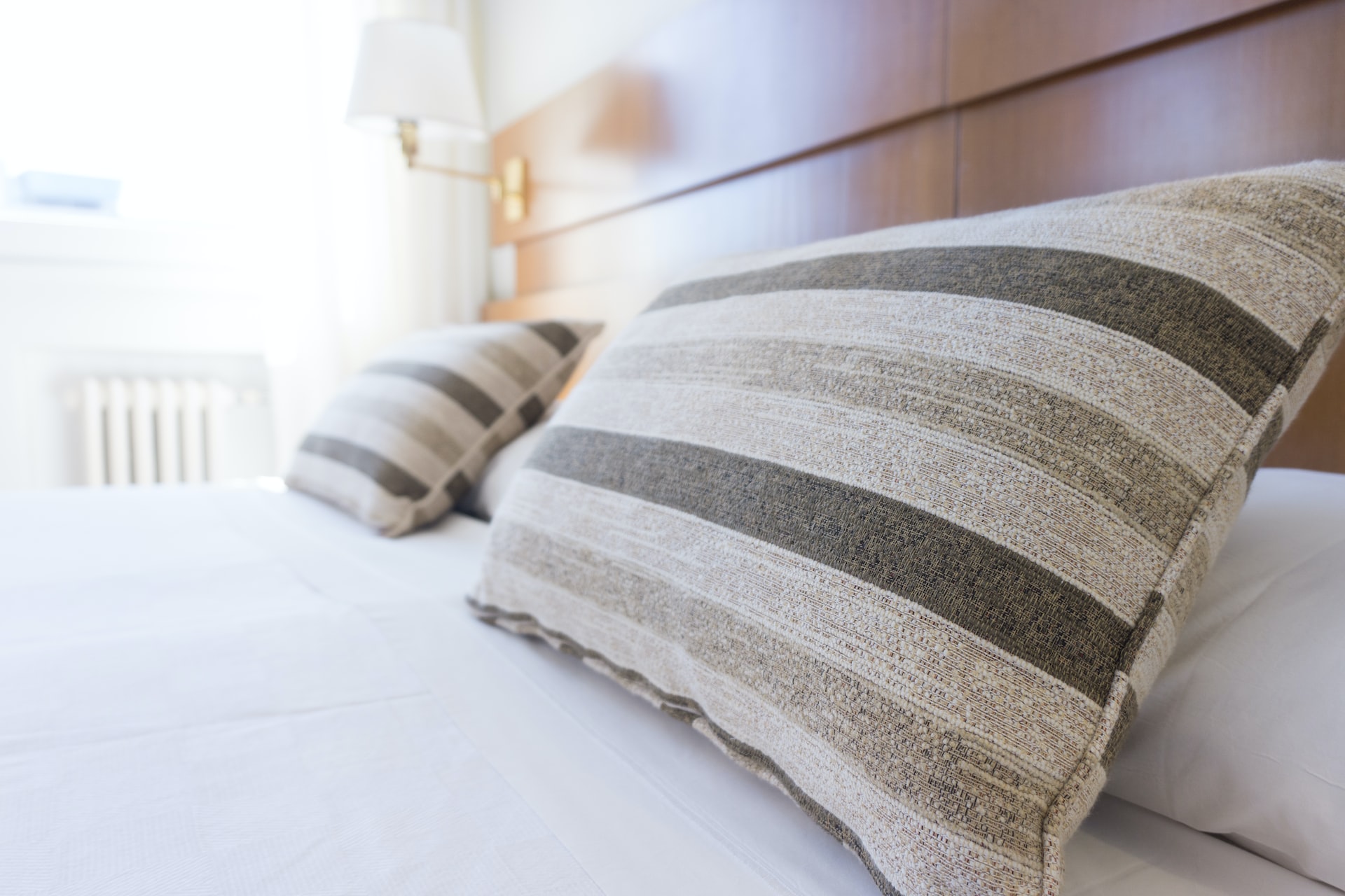 ホテルのベッドの上に並んだ2つのしま模様の枕